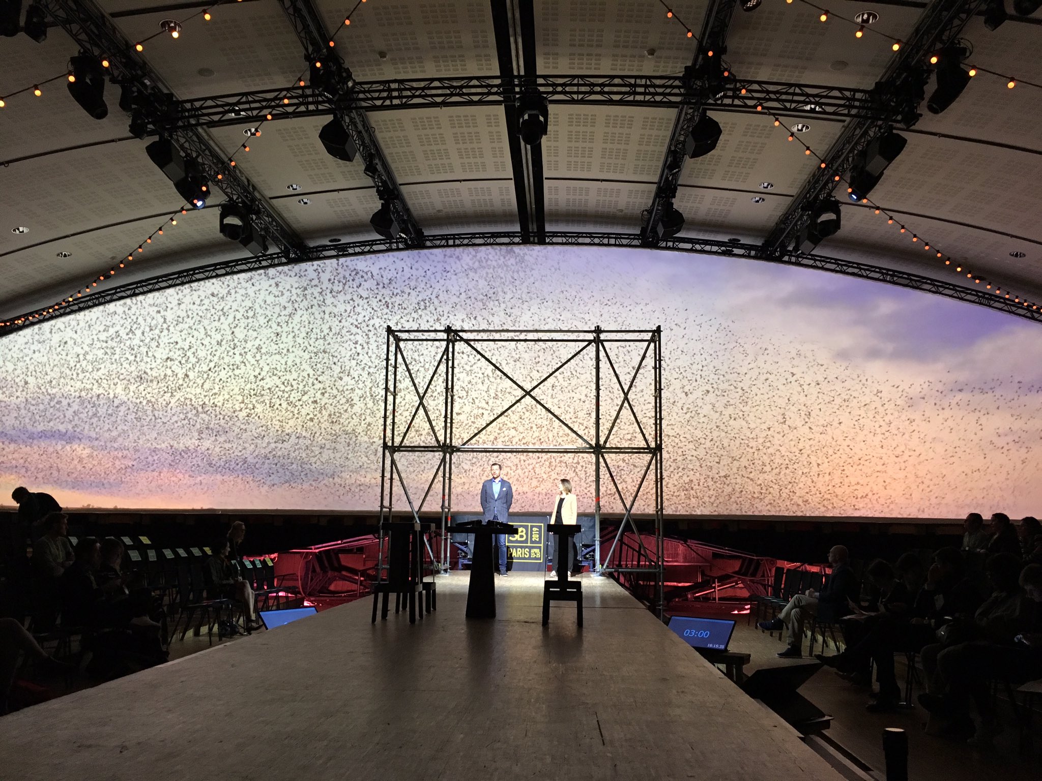 Vincent Avanzi on stage before a murmuration of birds and a shared horizon